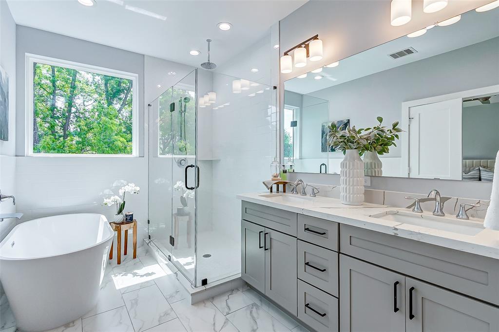 a spacious bathroom with a granite countertop sink a toilet a mirror and shower