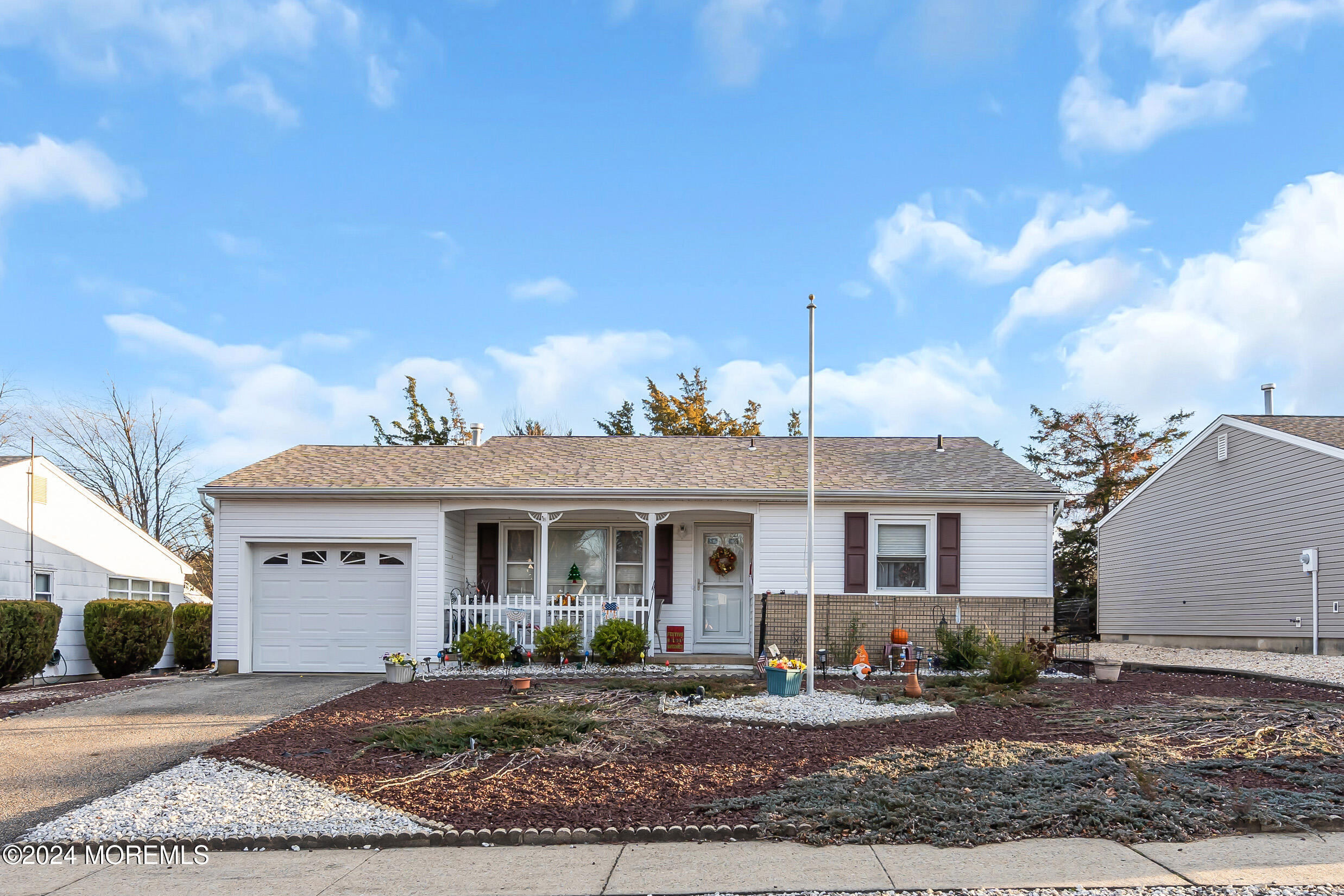 a front view of a house with yard and parking