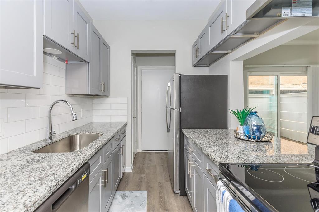 a kitchen with stainless steel appliances granite countertop a sink dishwasher and stove