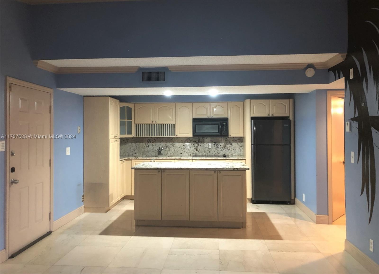 a view of kitchen with stainless steel appliances wooden cabinet and refrigerator