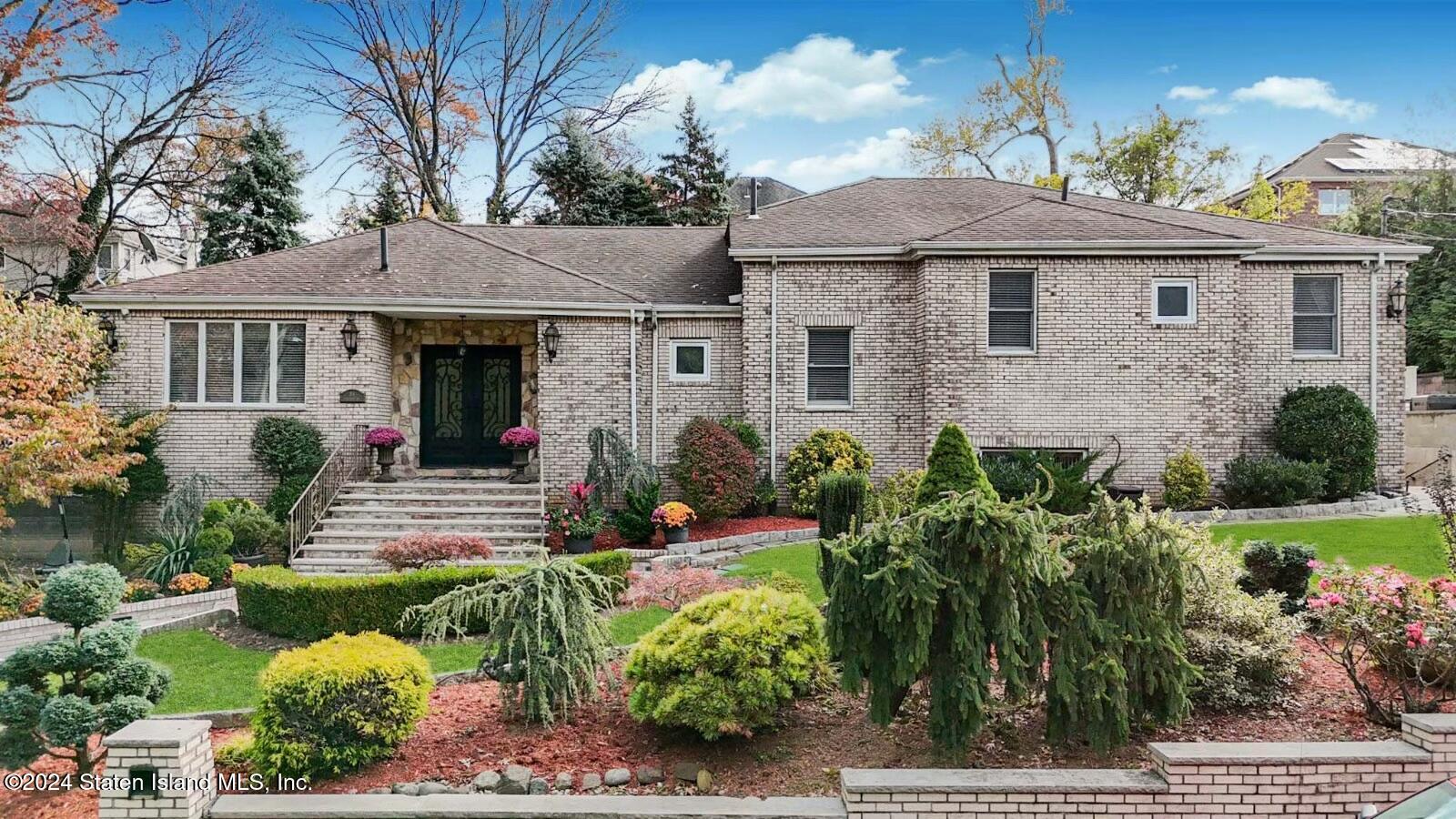 a front view of a house with a yard and potted plants