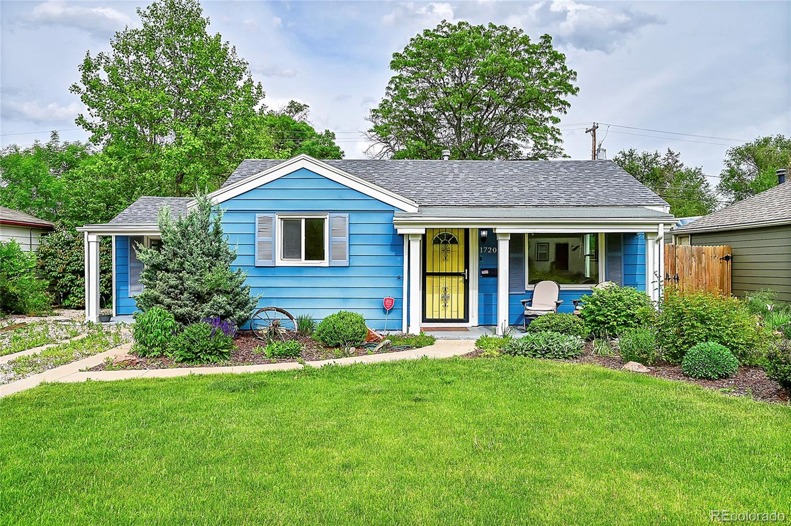 a front view of a house with a yard and trees