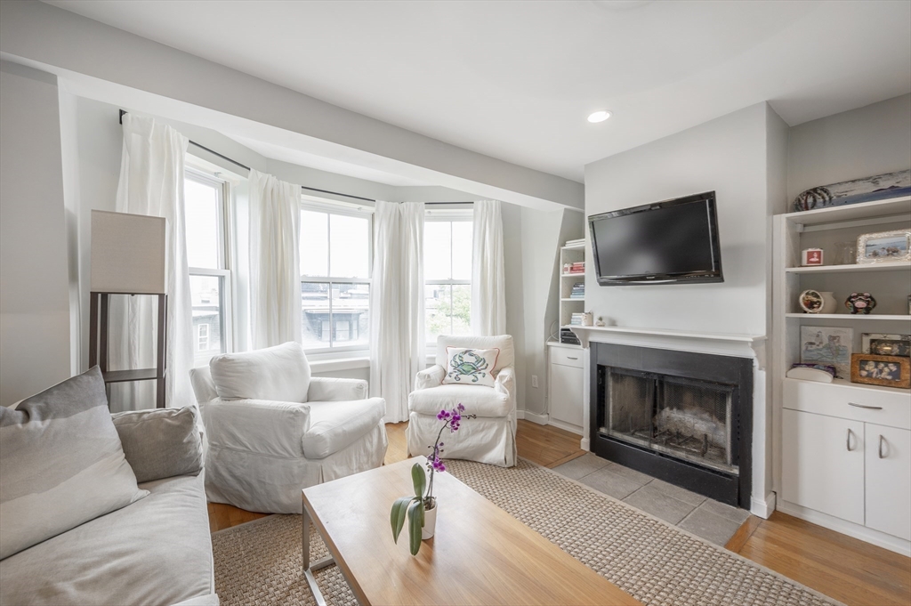 a living room with furniture a fireplace and a flat screen tv