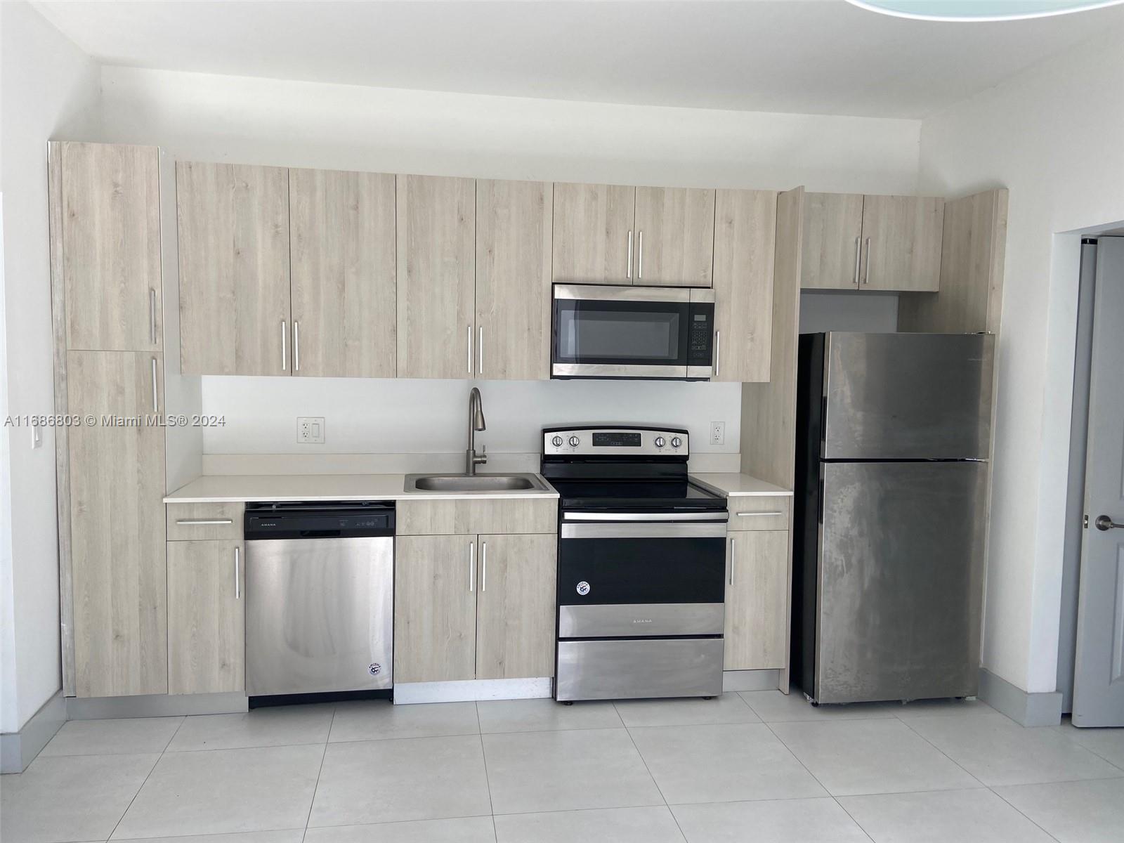 a kitchen with a refrigerator sink and microwave