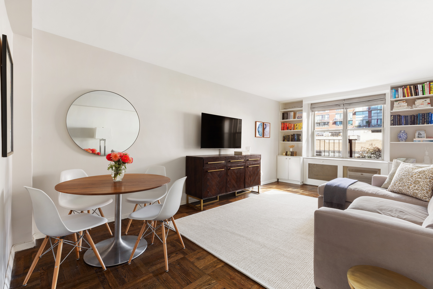 a living room with furniture a flat screen tv and a large window