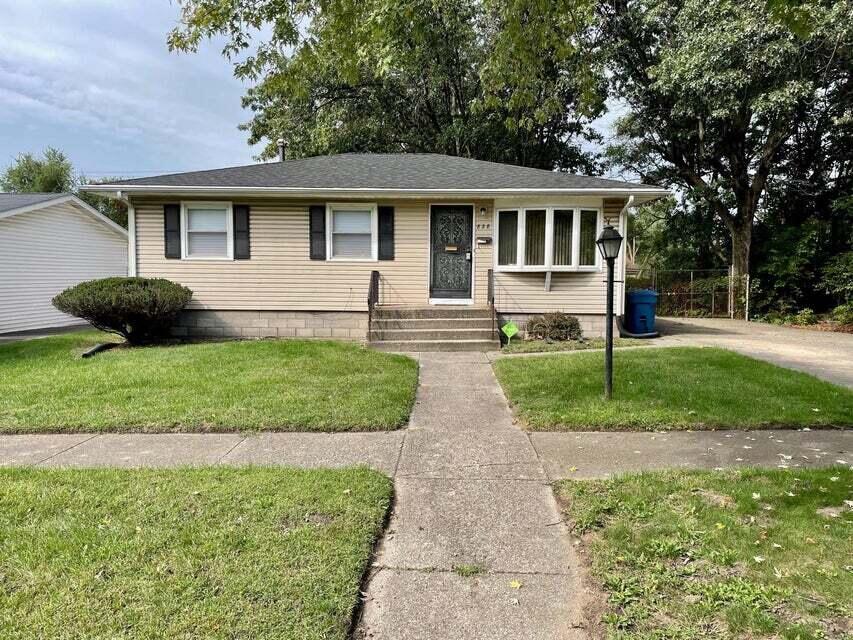 a front view of a house with a yard and outdoor seating