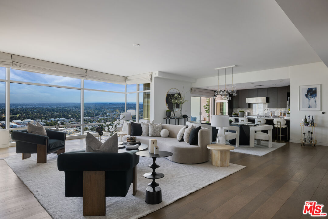 a living room with furniture large window and a table