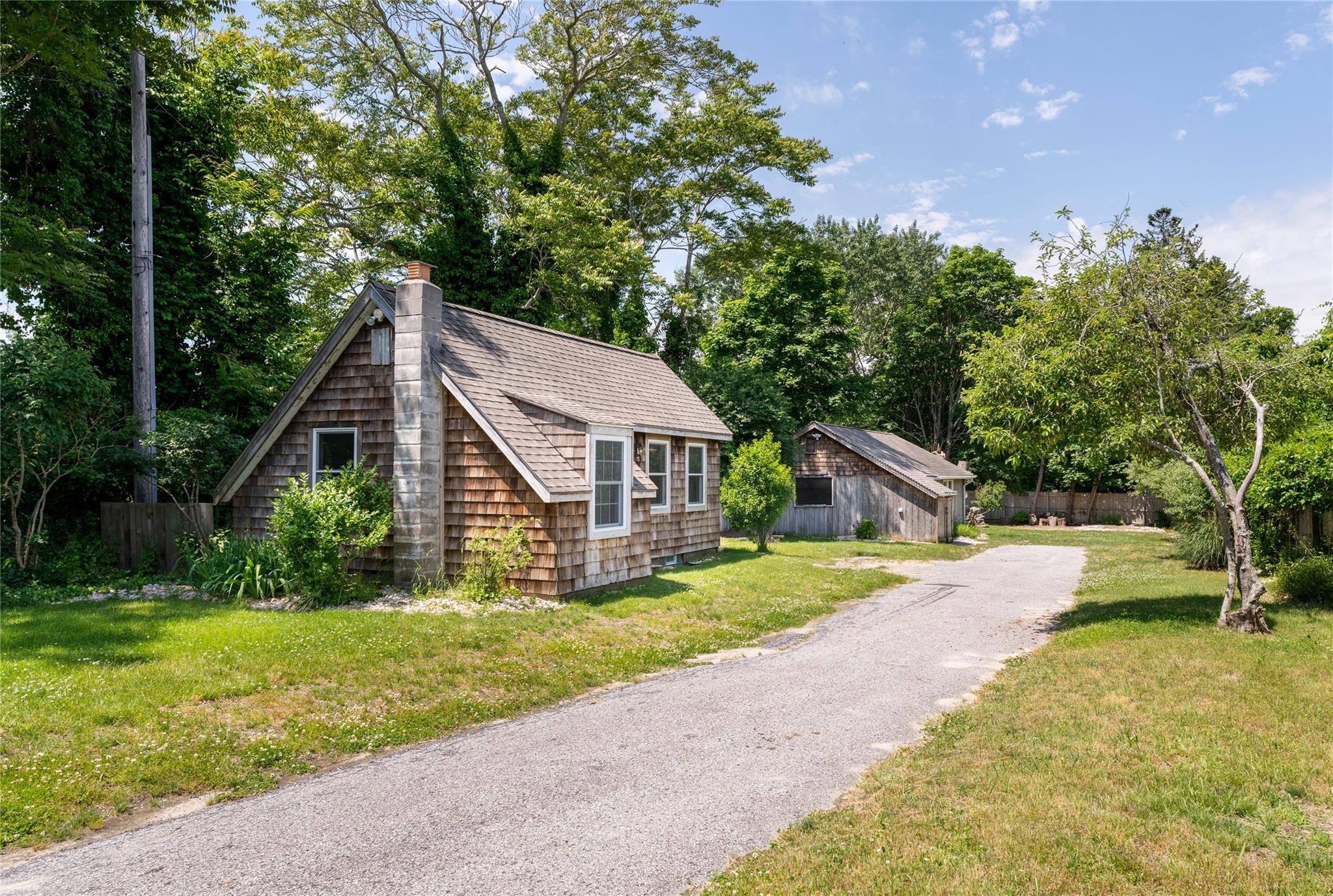 a view of a house with a yard and large trees