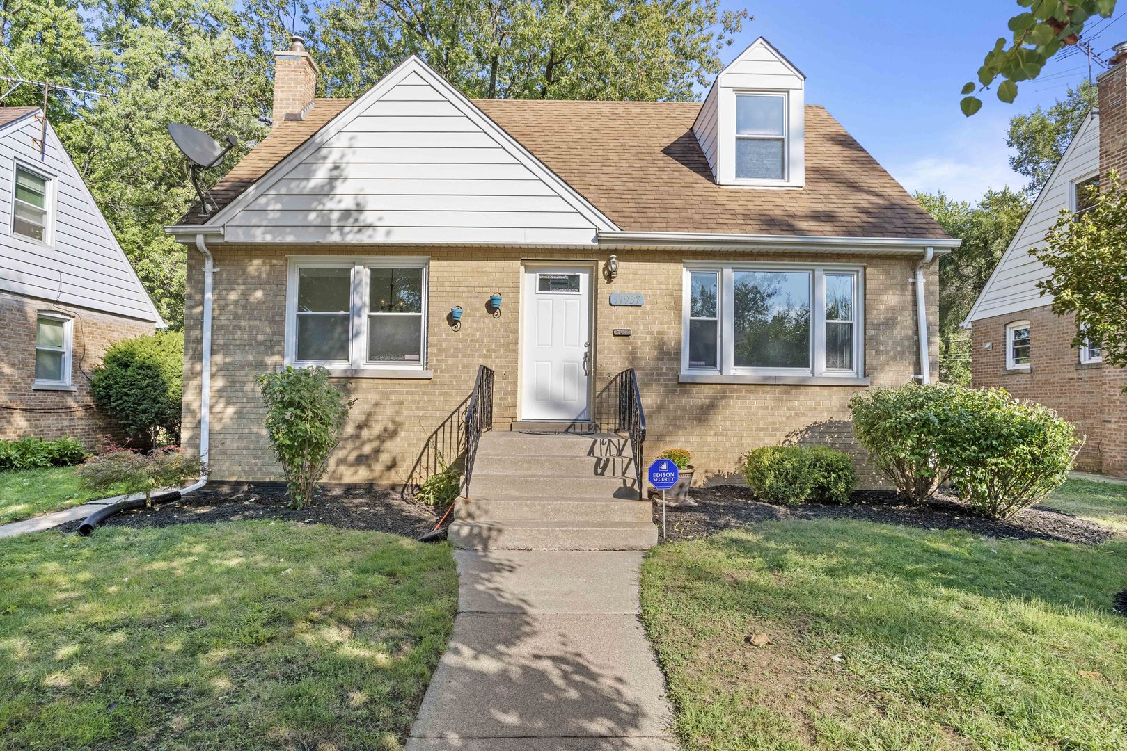 a front view of a house with a yard and potted plants