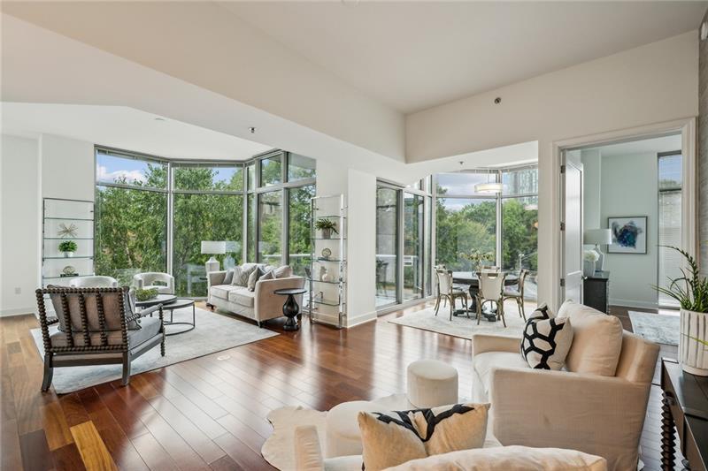 a living room with furniture and floor to ceiling windows