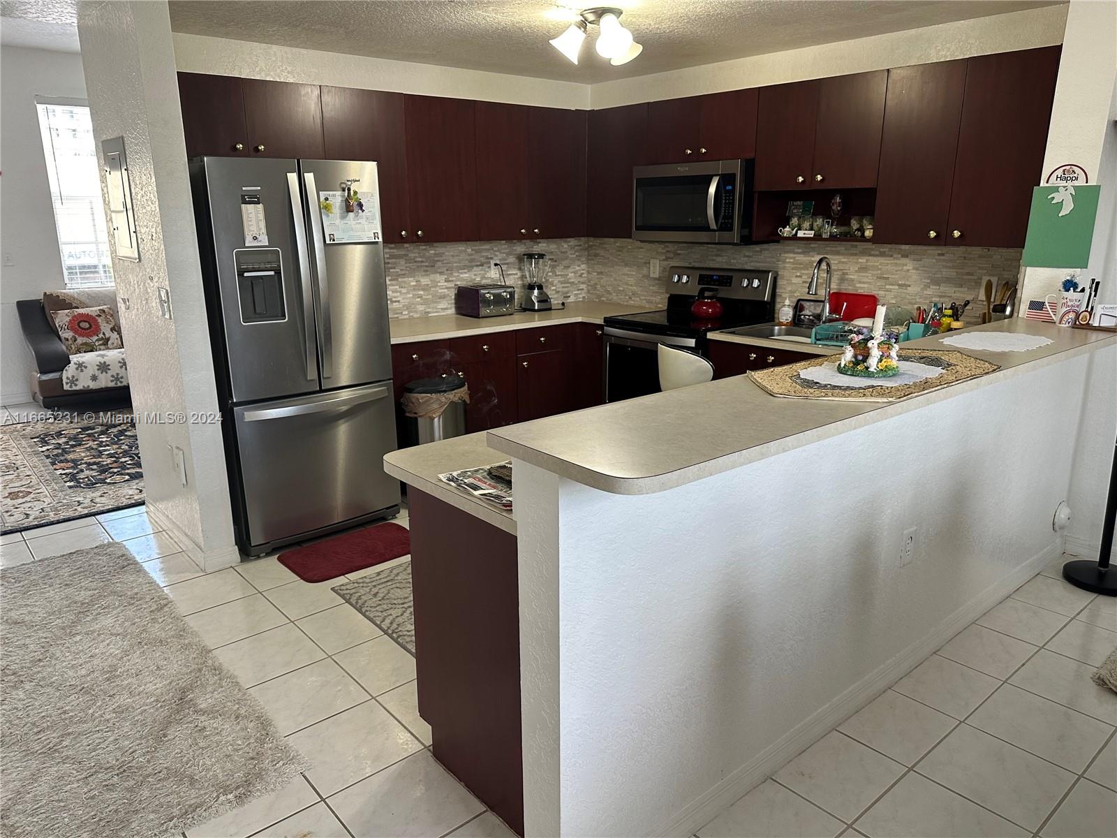 a kitchen with stainless steel appliances a refrigerator sink and microwave