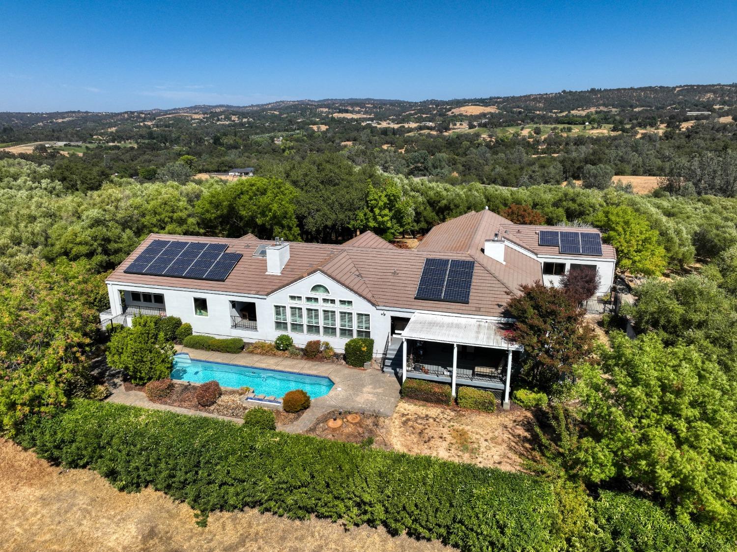 an aerial view of residential houses with outdoor space and trees