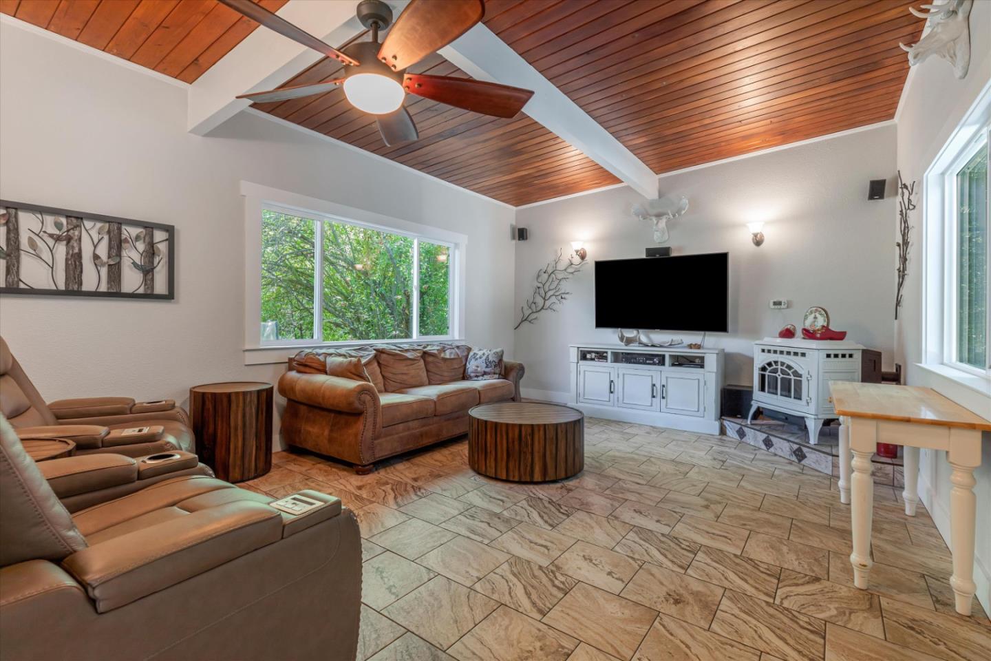 a living room with furniture a flat screen tv and a chandelier