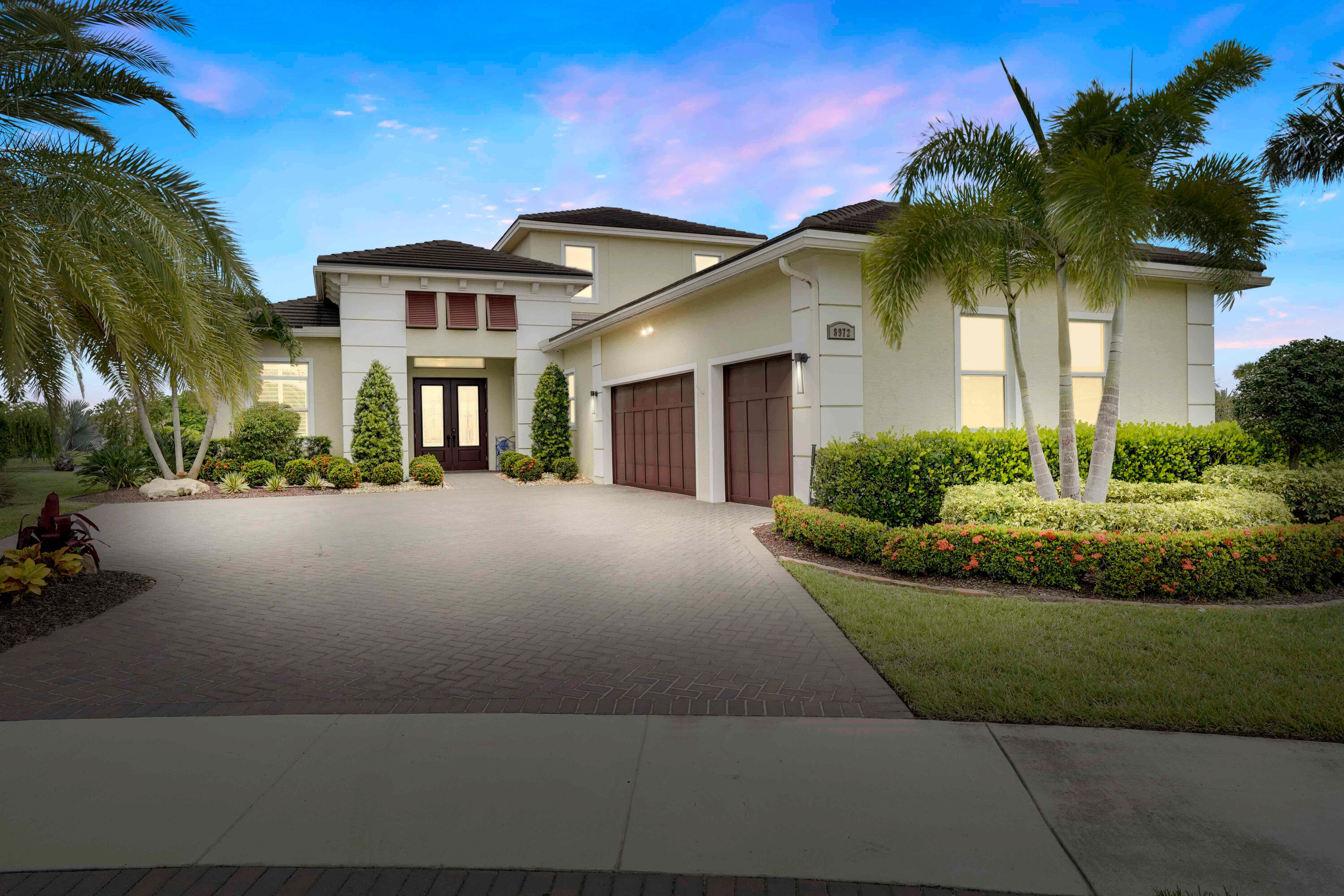 a front view of a house with a yard and potted plants