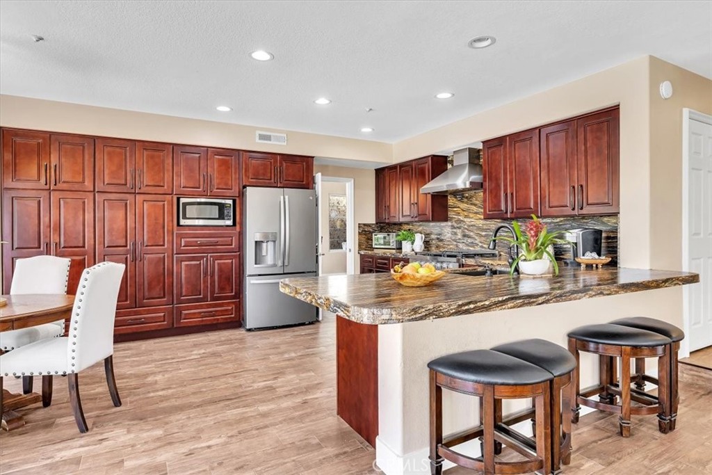 a kitchen with granite countertop wooden cabinets and stainless steel appliances