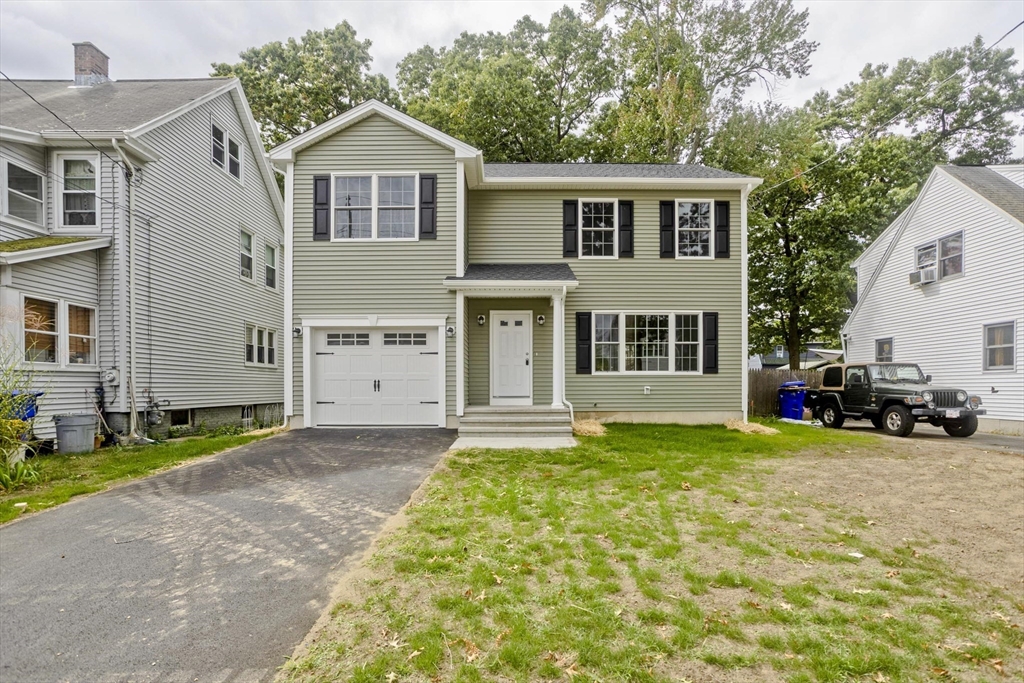 a view of a house with a patio and a yard