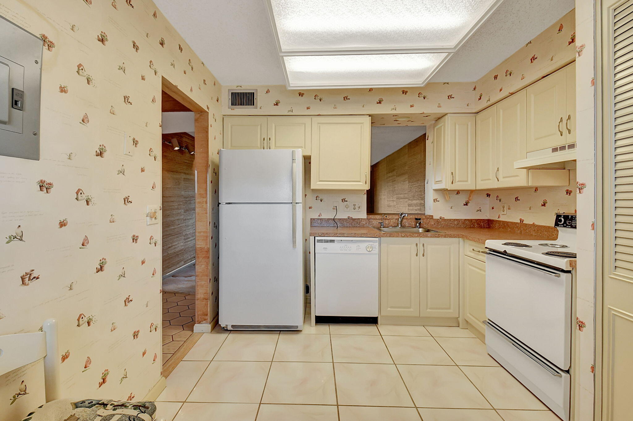 a kitchen with a refrigerator a stove top oven and cabinets