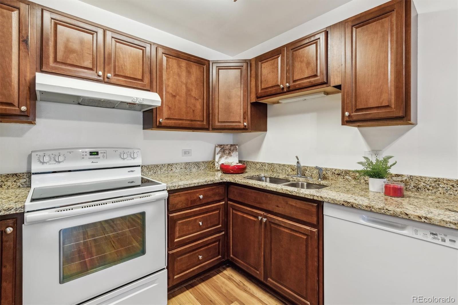 a kitchen with granite countertop cabinets stainless steel appliances and a sink