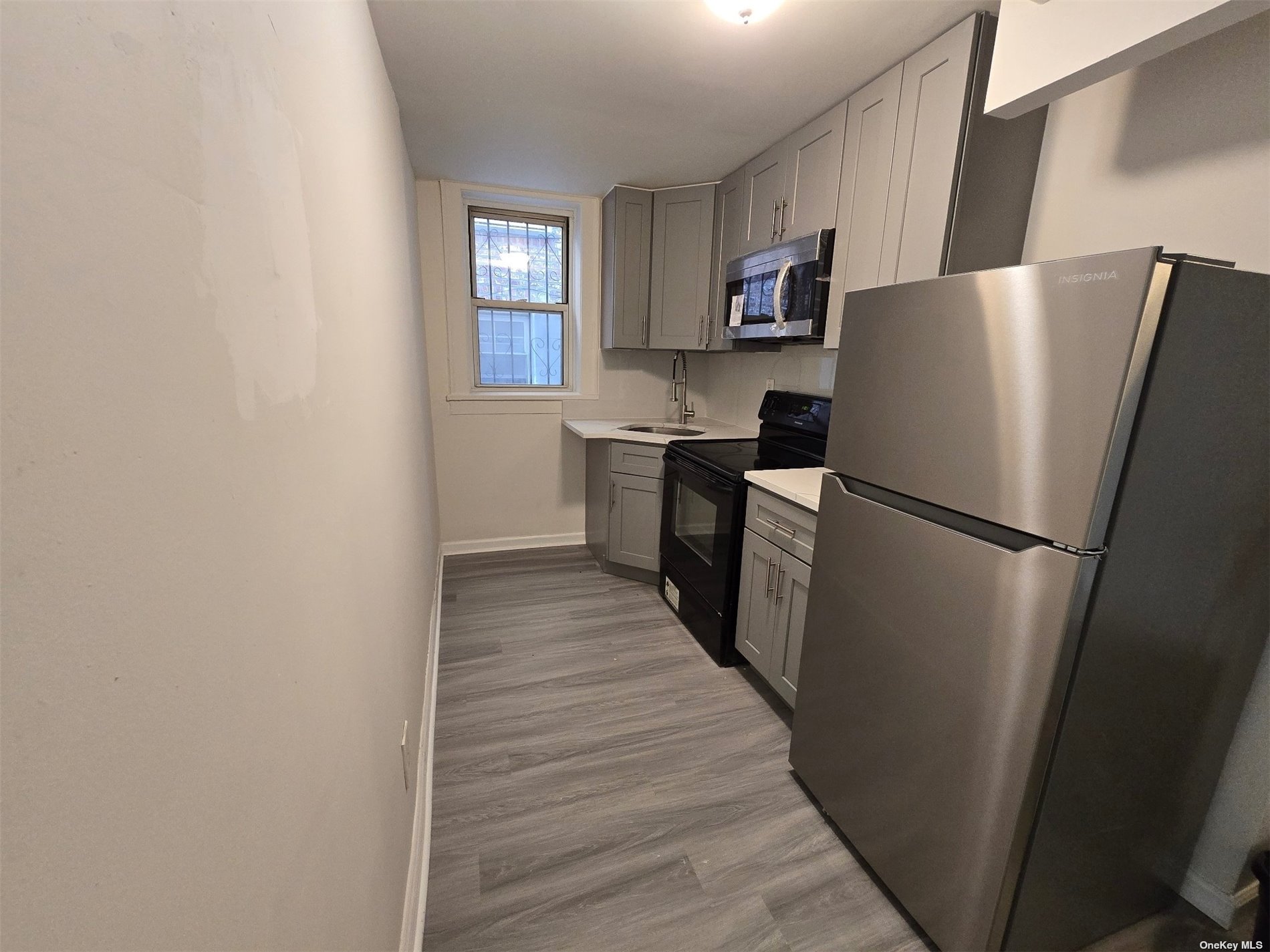 a kitchen with a refrigerator a stove top oven and wooden floor