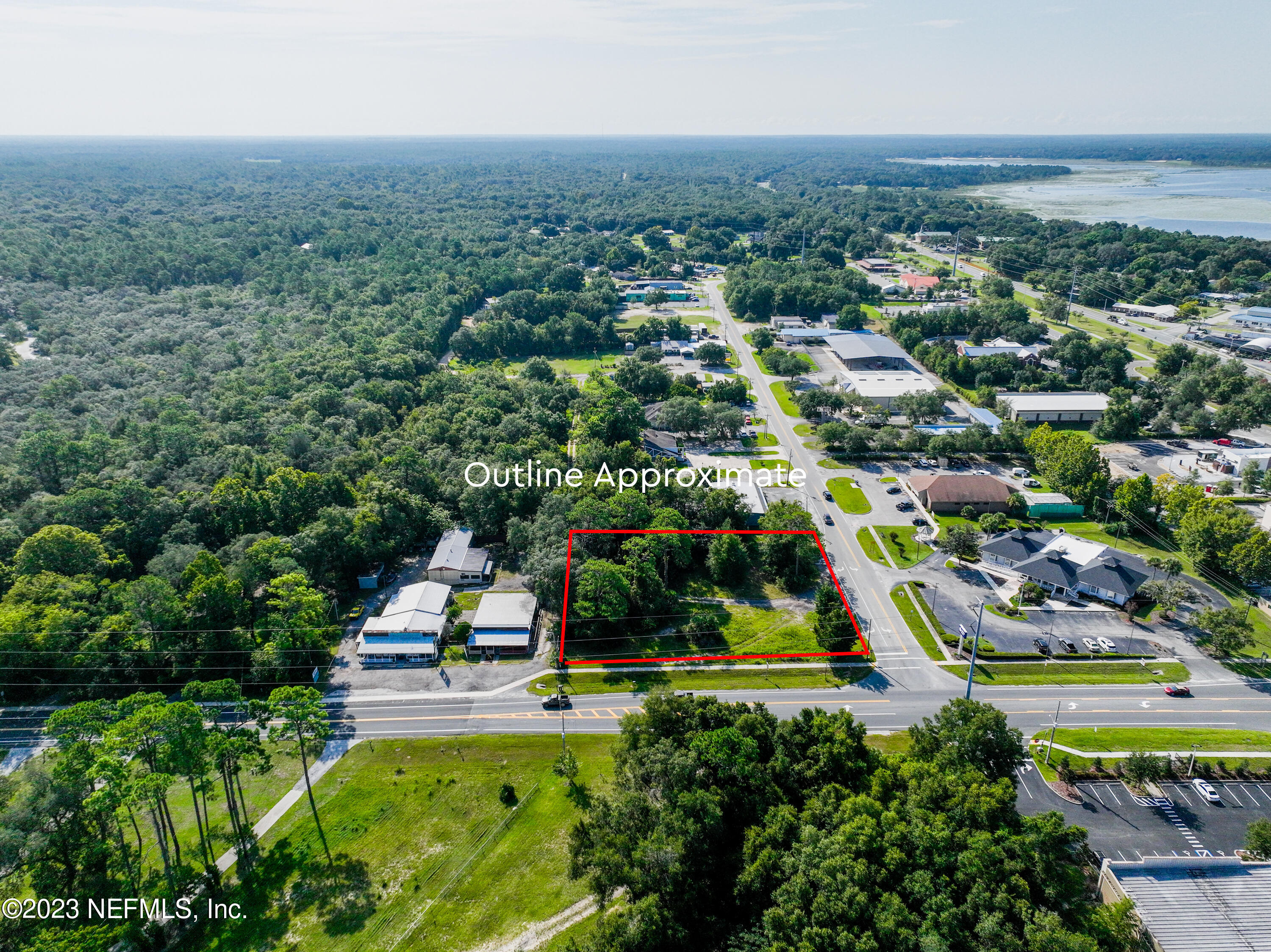 an aerial view of residential houses with outdoor space and trees