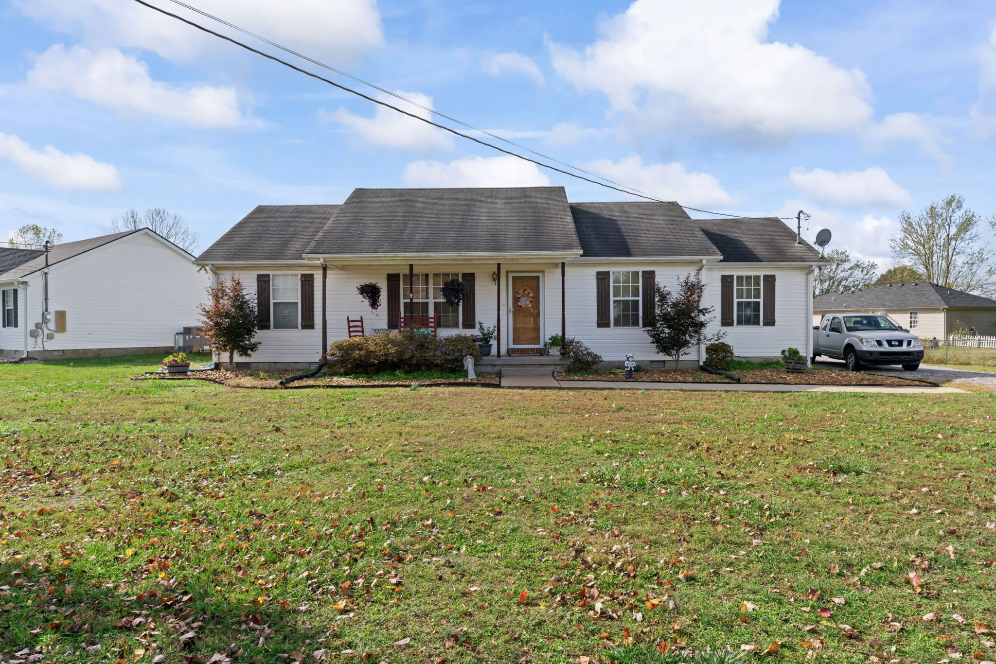 a front view of a house with a garden and trees