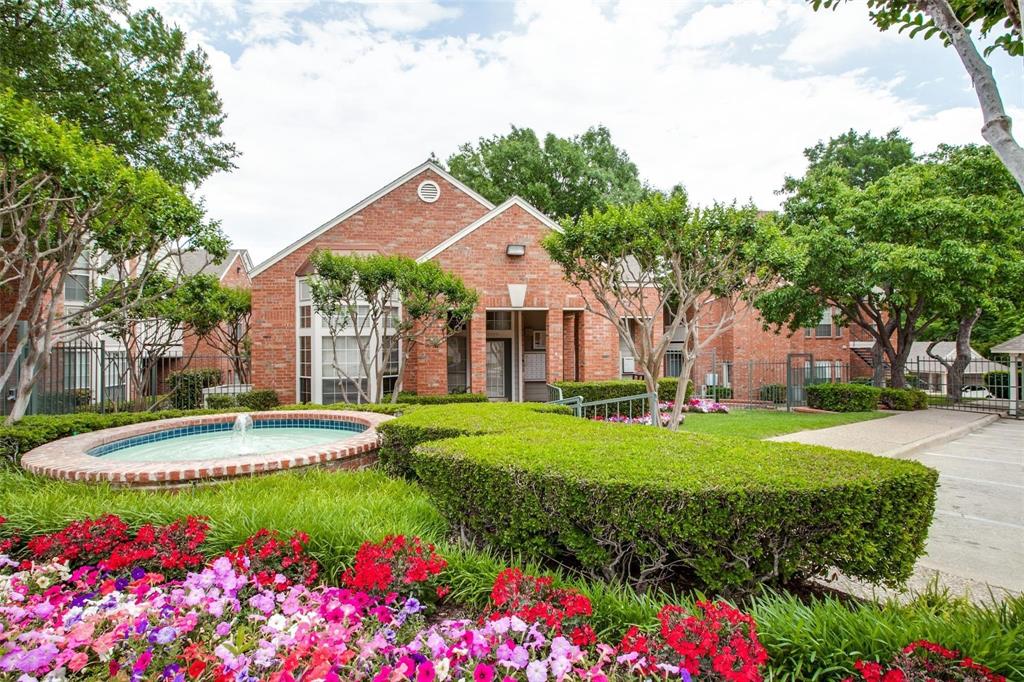 a front view of a house with a yard and fountain