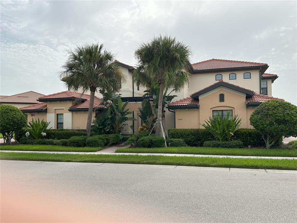 a front view of a house with a yard and potted plants