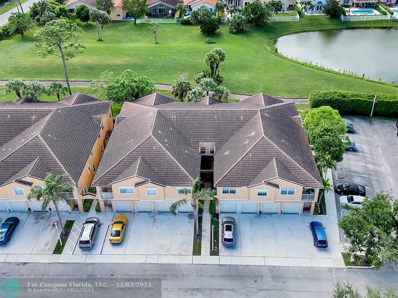 an aerial view of a house with outdoor space lake view and a ocean view in back