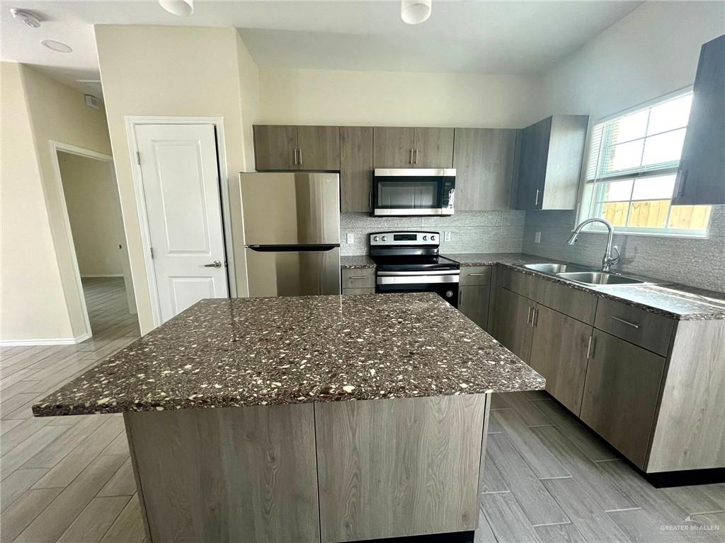 Kitchen featuring sink, a center island, light hardwood / wood-style flooring, and stainless steel appliances