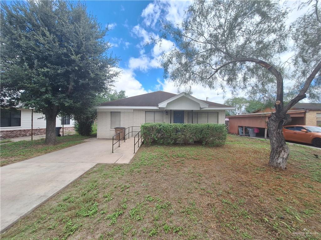 a view of a house with a yard and large tree