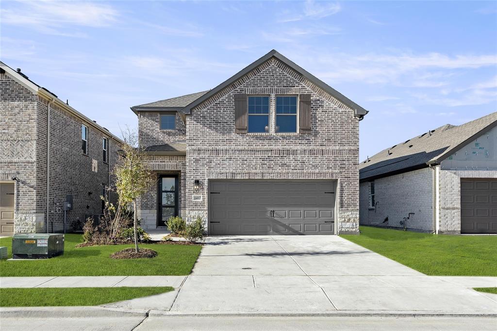 a front view of a house with a yard and garage