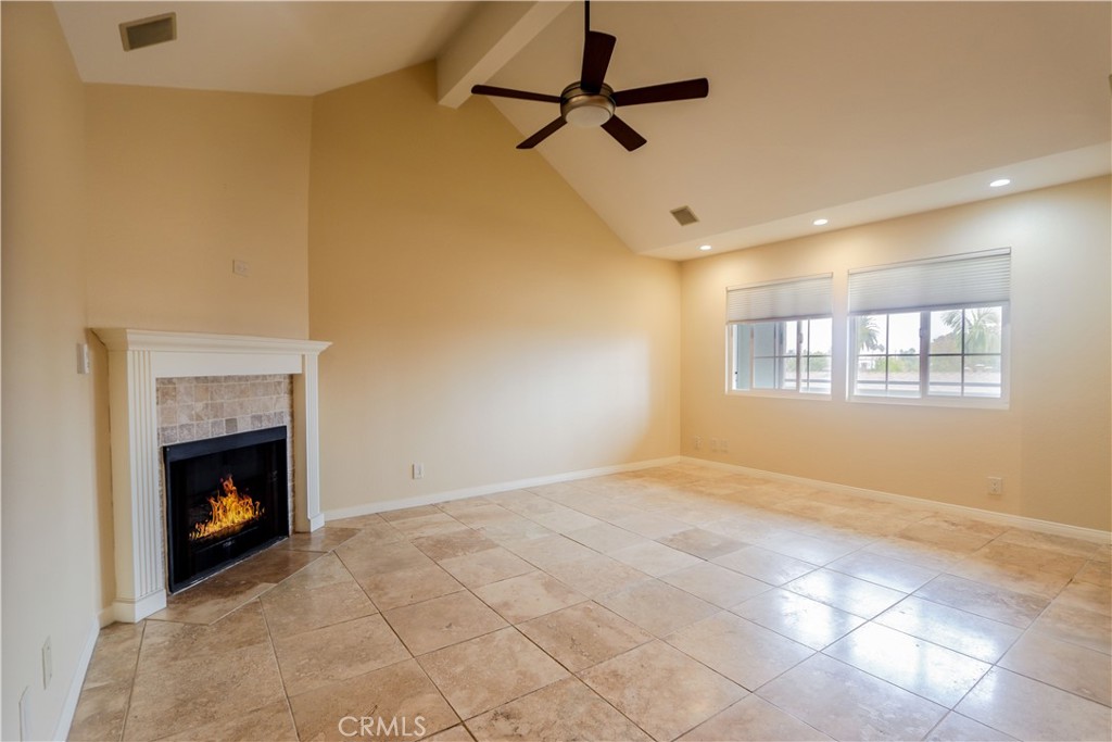 a view of empty room with fireplace and windows