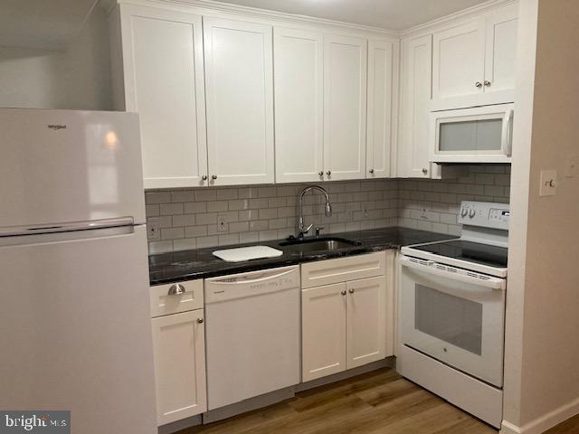 a kitchen with white cabinets and white appliances