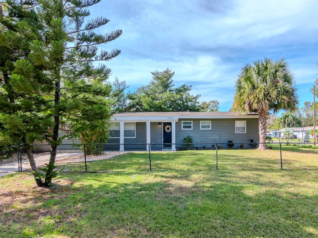 a view of a house with a yard and tree s