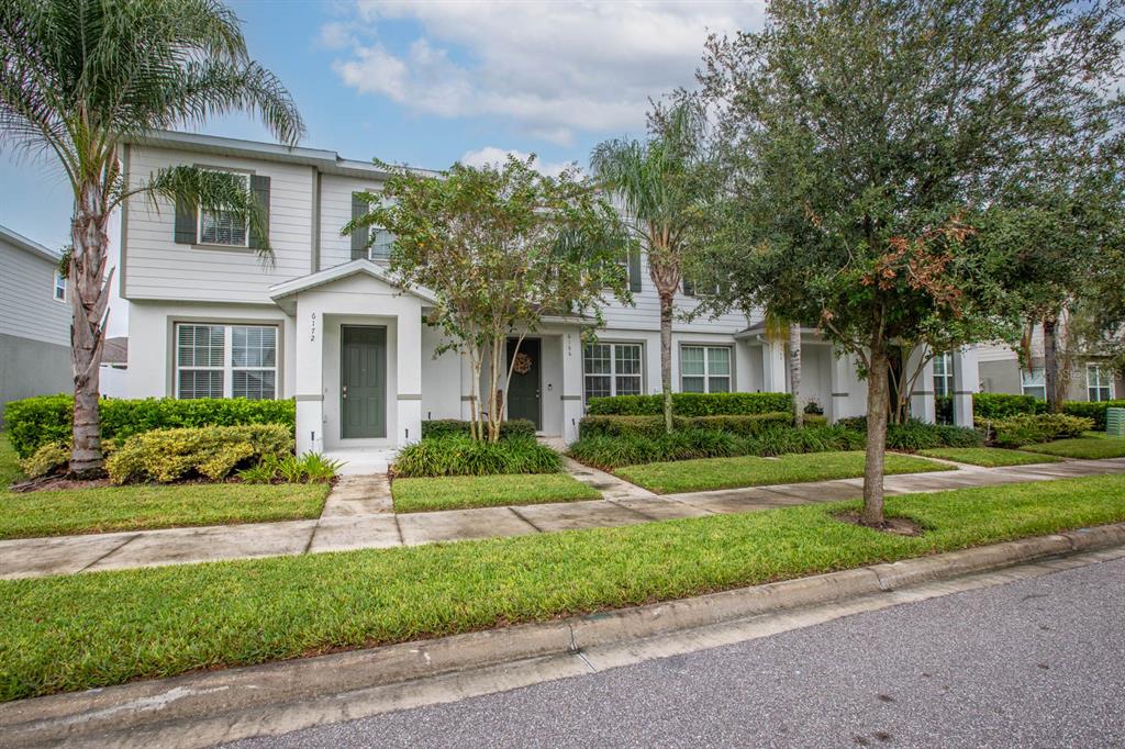 a front view of a house with a yard and green space