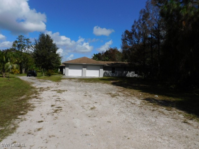 a view of house with backyard and a garden