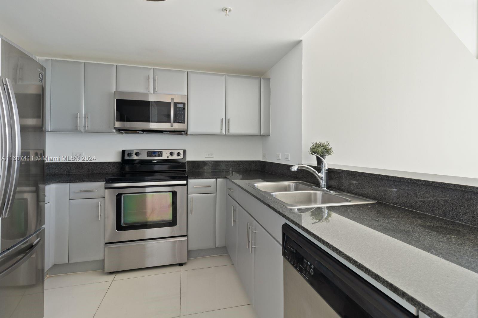 a kitchen with stainless steel appliances granite countertop a sink stove and microwave