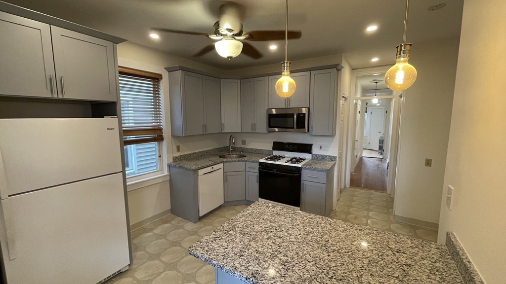 a kitchen with a refrigerator and a stove top oven