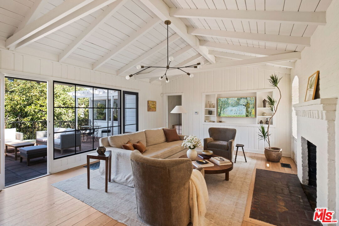 a living room with furniture a fireplace and a floor to ceiling window