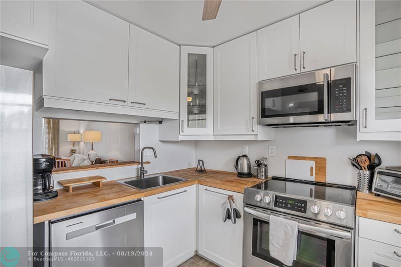 a kitchen with stainless steel appliances granite countertop a sink a stove a microwave and cabinets