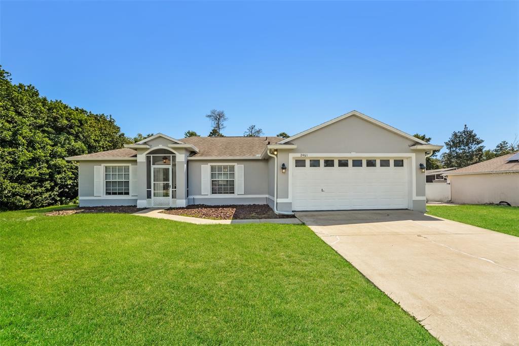 a view of a house with a yard and garage