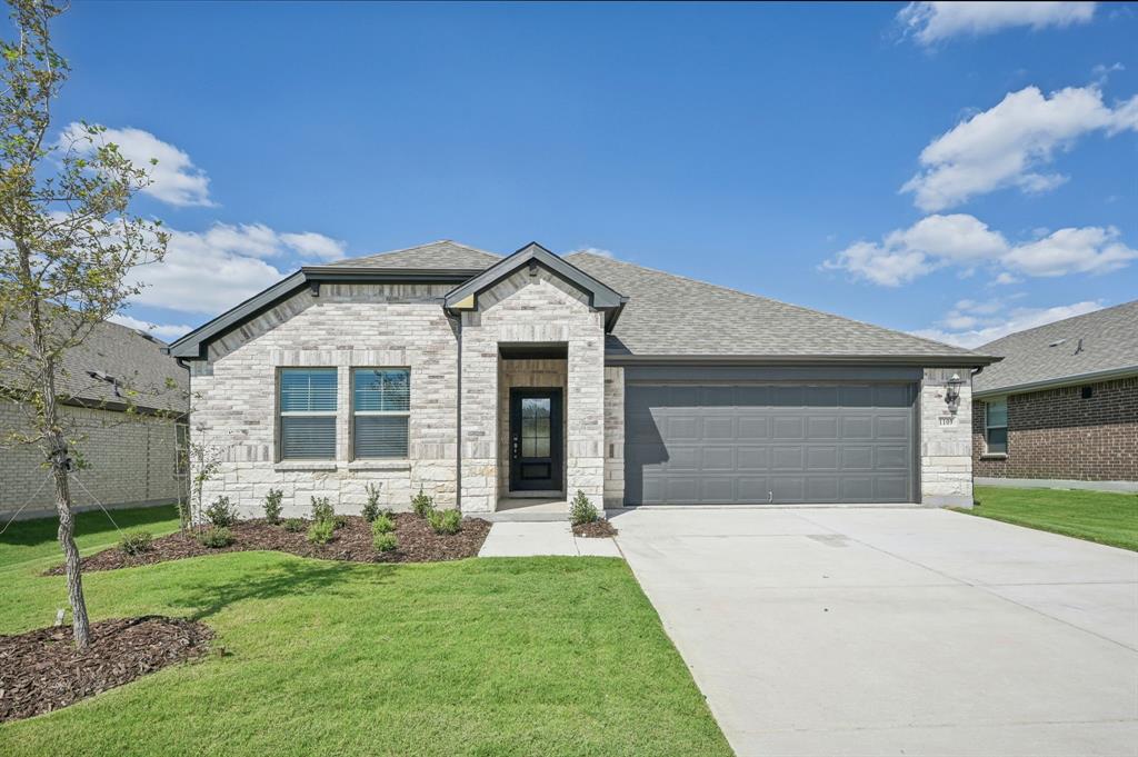 a front view of a house with a yard and garage