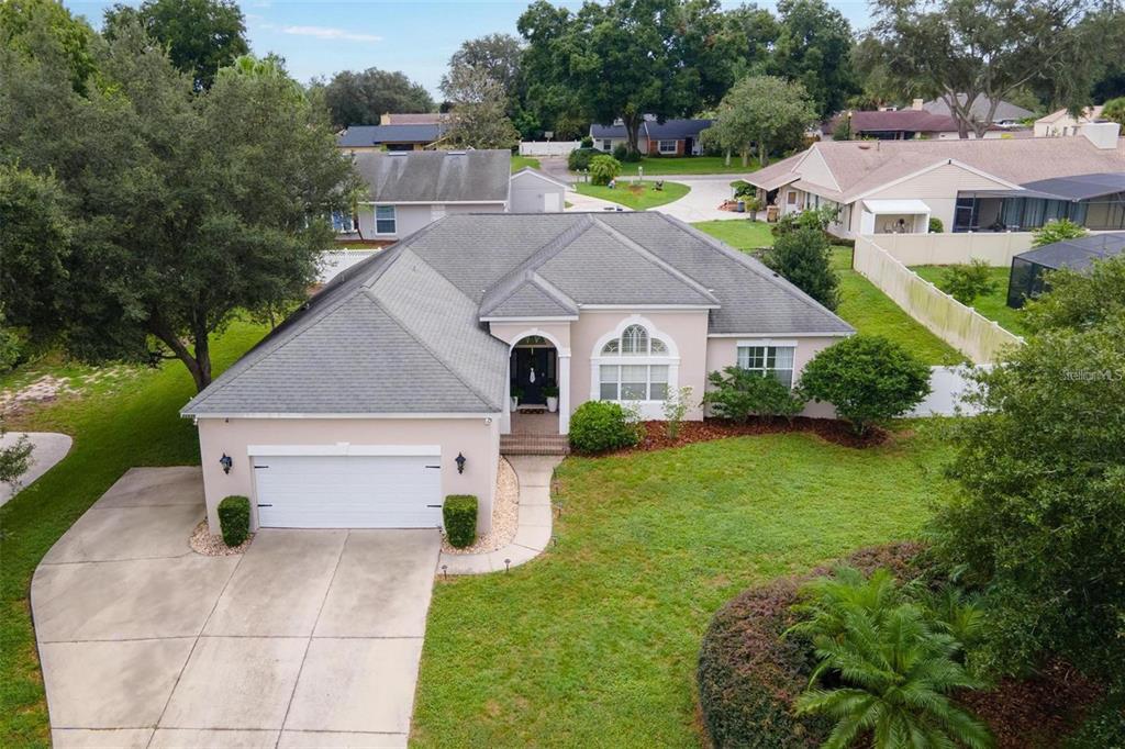 an aerial view of a house with swimming pool next to a yard