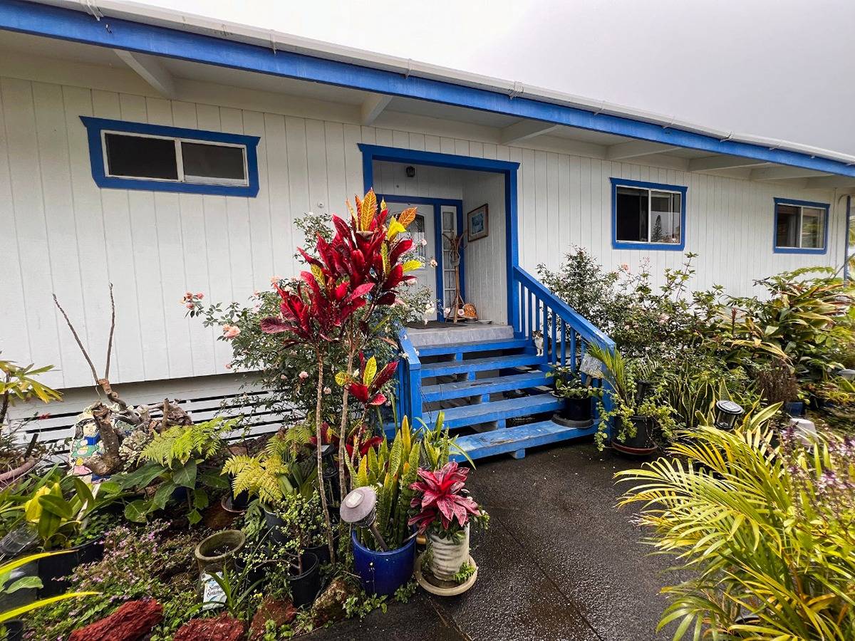 a front view of a house with lots of flowers