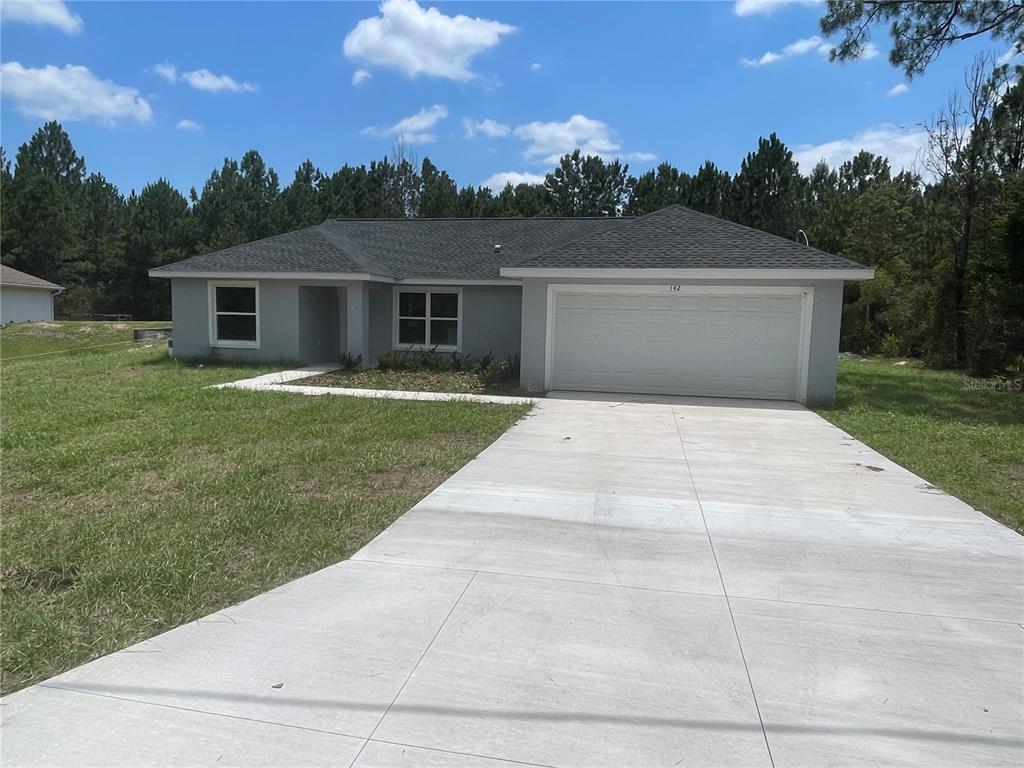 a front view of a house with a yard and trees