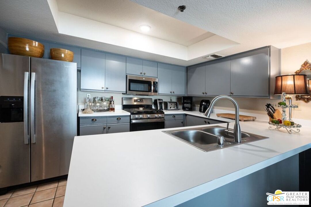 a kitchen with kitchen island a sink stainless steel appliances and cabinets