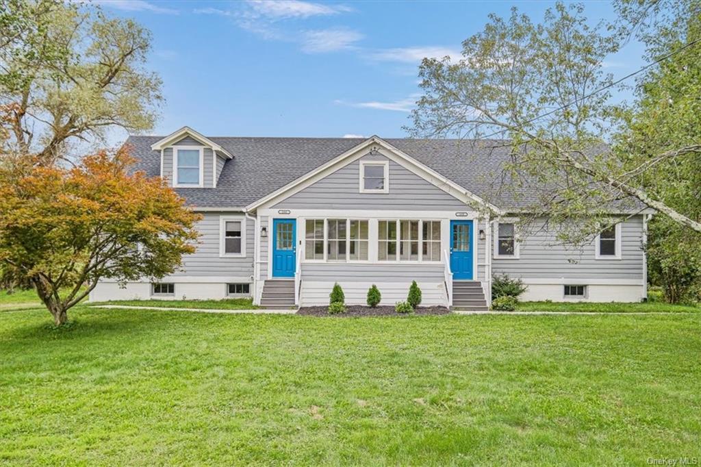 a front view of a house with a yard and trees