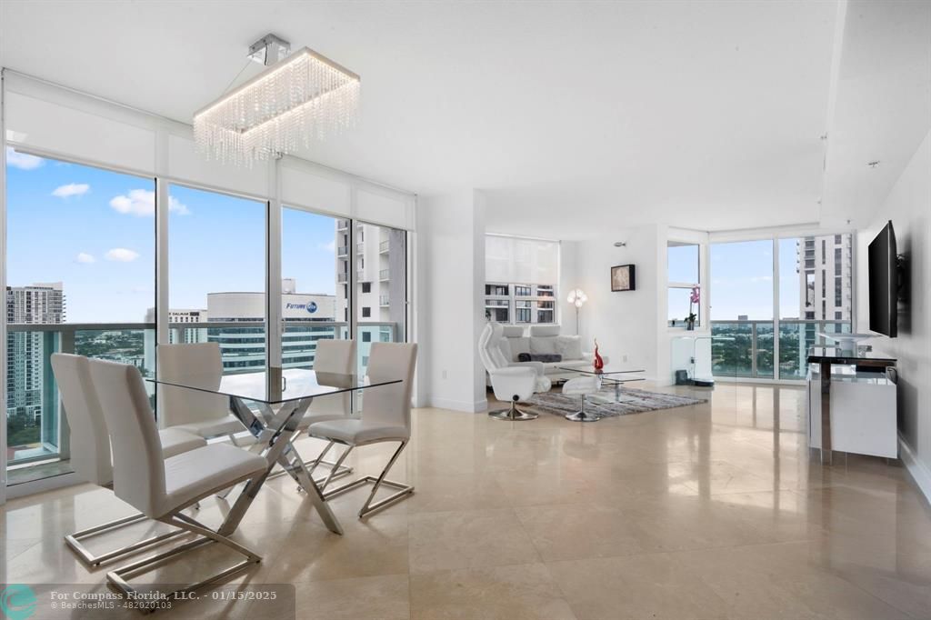 a living room with furniture and a flat screen tv with kitchen view