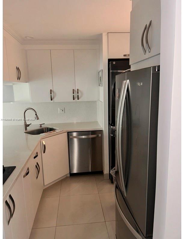 a kitchen with a sink a refrigerator and cabinets