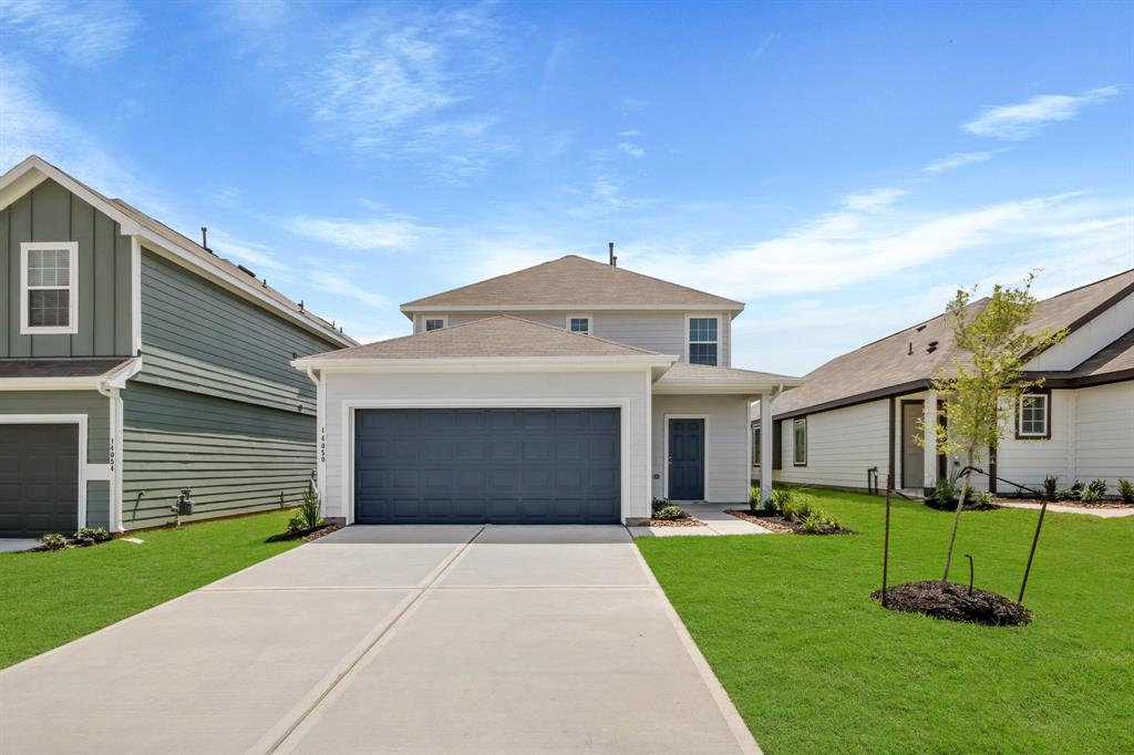 a front view of a house with a yard and garage